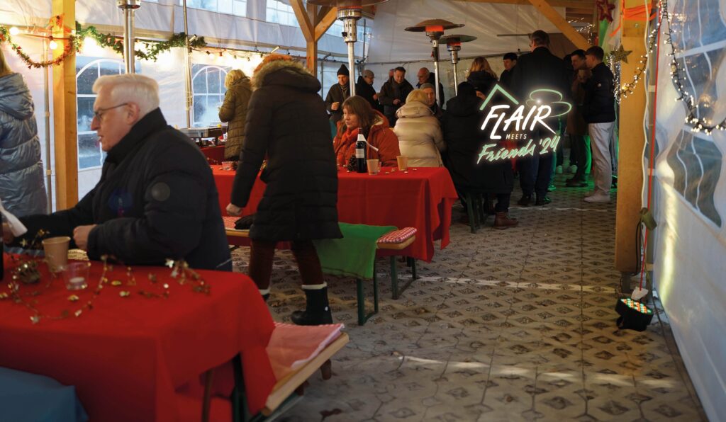 Gäste in Winterjacken in festlich dekoriertem Zelt – FLAIR meets Friends 2024