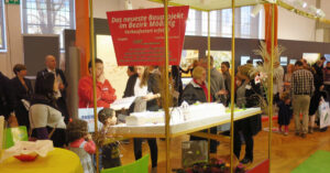 Besucher betrachten Architekturmodell auf Messestand im Bezirk Mödling