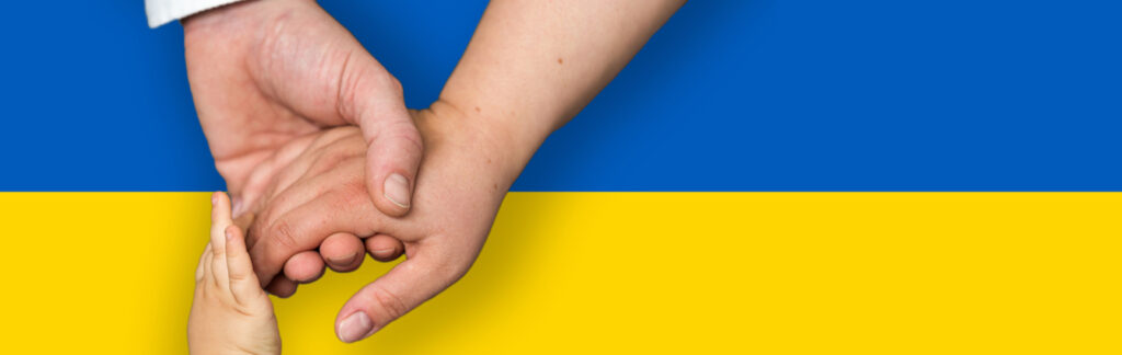 Hände greifen einander vor ukrainischer Flagge – Solidarität mit der Ukraine