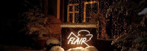 Leuchtendes FLAIR-Logo im Schnee bei abendlicher Winterfeier – meets Friends 2023