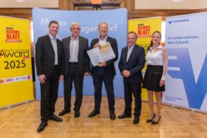 Team mit Urkunde vor Volksbank-Banner – Business Award Liesing 2025